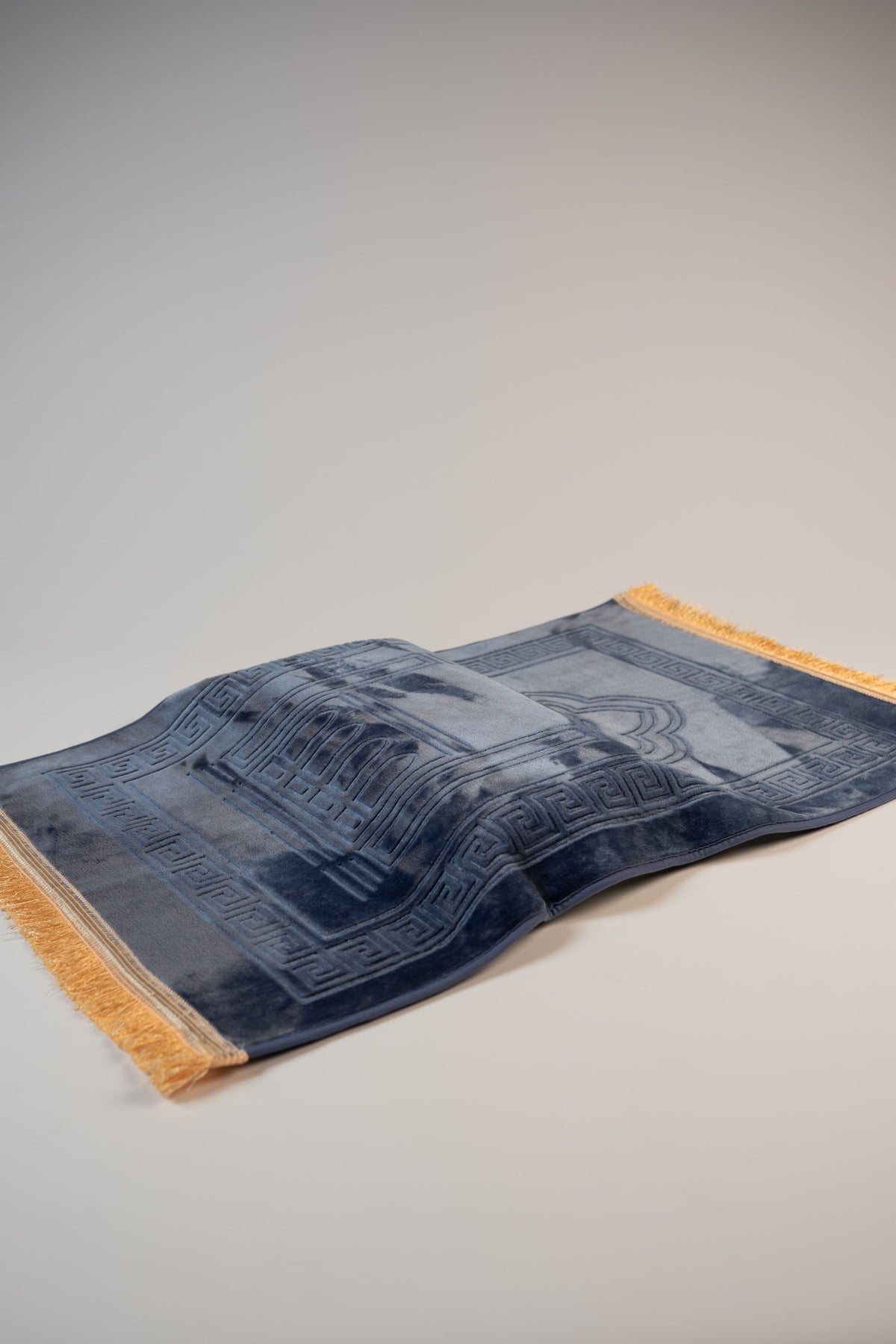 Ergonomic prayer mat in Navy Blue, angled view