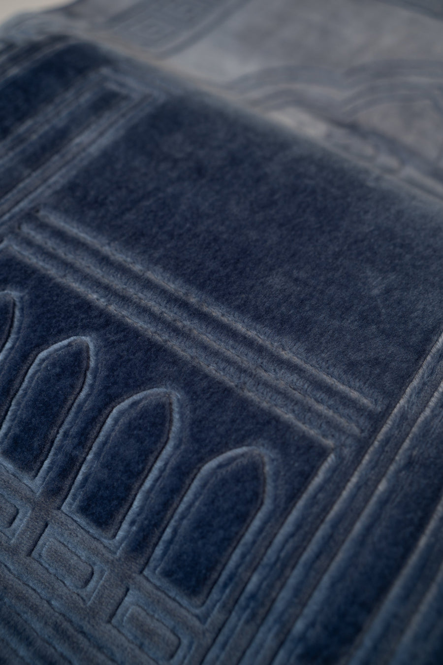 Embossed mihrab detail on the velvet surface