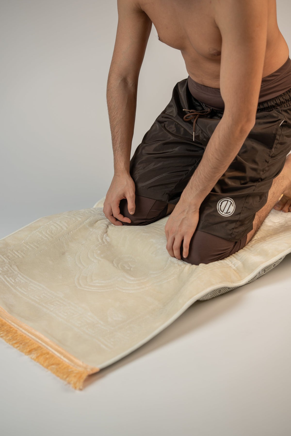 Man kneeling on the Beige ergonomic prayer mat